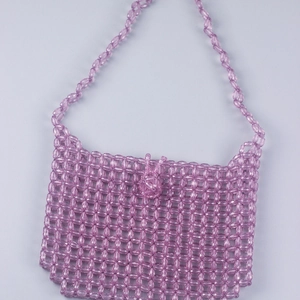 Macro view of handmade purple transparent beaded mini bag with acrylic woven texture