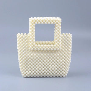 Macro shot of handcrafted cream acrylic bead woven handbag with square hollow handles