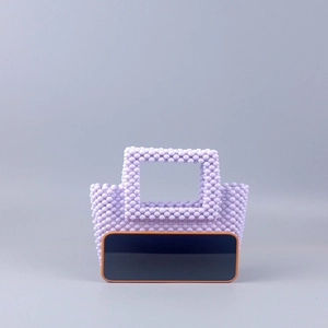 Detail view of handmade lilac acrylic beaded clutch showing texture and phone size reference