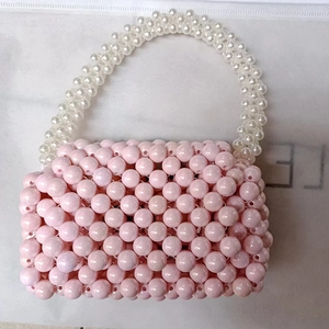 Pink acrylic beaded handbag with white pearl-style handle and retro woven design