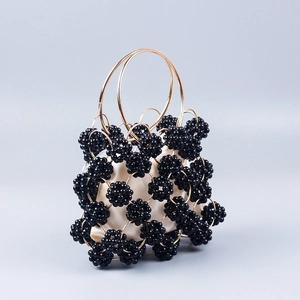 Handcrafted black beaded ball bag with gold metal rings and cream fabric liner