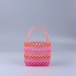 Detail of hand-woven acrylic crystal beads in pink and orange gradient bucket bag