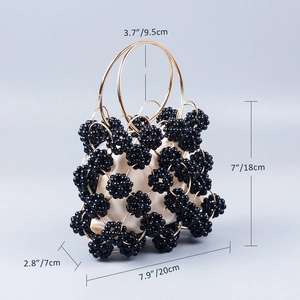 Detailed view of black beaded evening bag with gold metal rings and satin drawstring bag