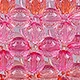 Macro view of pink gradient faceted acrylic beads with detailed hand-woven texture