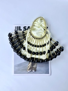 Detailed top view of fan-shaped evening bag with black beads and pearl ring handle