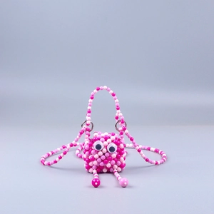 Detailaufnahme der handgefertigten Perlen-Minifroschtasche mit rosa Perlenstruktur