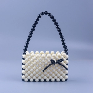 Handmade cream acrylic beaded handbag with black bow decoration and bead handle