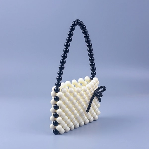 Handmade cream acrylic beaded handbag with black floral accent and slim shoulder strap