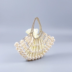 Elegant shell-shaped pearl handbag with golden metal frame and satin drawstring pouch