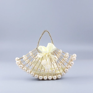 Detail of fan-shaped pearl evening bag with golden metal frame and satin drawstring