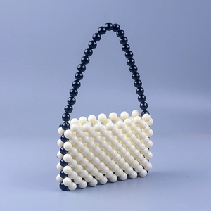 Detailed view of hand-woven milky white acrylic beads with black contrast top handle