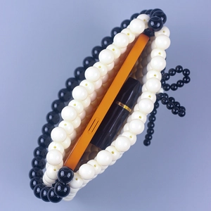 Handmade woven acrylic bead handbag in black and white pattern showing interior capacity