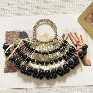 Detail of fan-shaped beaded clutch with black beads, metal frame and satin drawstring inner