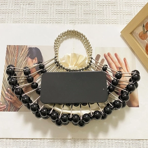 Detailed top view of beaded fan-shaped handbag showing interior capacity with a smartphone