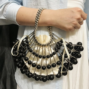 Detail of fan-shaped evening clutch with silver tubes, black beads and satin drawstring pouch