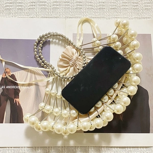 Detail of handmade pearl beaded evening bag with silver metal tubes and drawstring liner