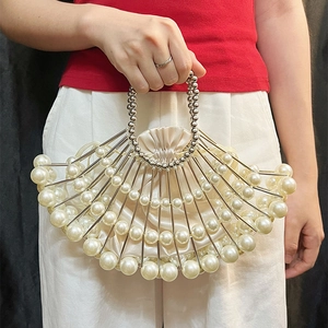 Detail of fan-shaped beaded clutch featuring white pearls and satin drawstring inner bag