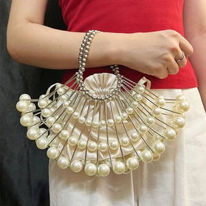 Close-up of fan-shaped pearl evening clutch with metallic tubes and satin lining