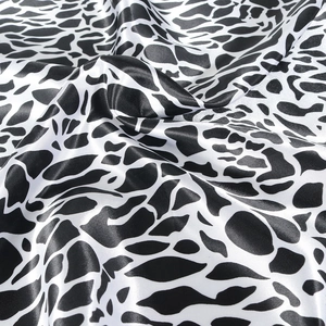 Detailed close-up showing the smooth satin texture and black leopard print of the scarf