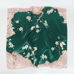 Detail of satin floral scarf with white plum blossom pattern on green and pink fabric