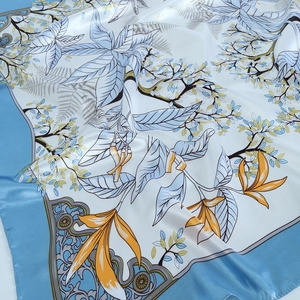 Détail d'un élégant carré en soie avec imprimés floraux bleus et texture satinée
