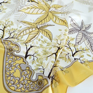Détail des plis en satin avec motifs de feuilles exotiques et bordures géométriques