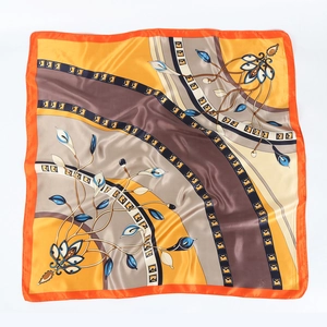 Détail d'un foulard en soie à imprimé fleuri avec bordures oranges et motifs rétro
