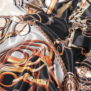 Luxurious satin silk scarf with vintage chain patterns in black, white, and gold tones