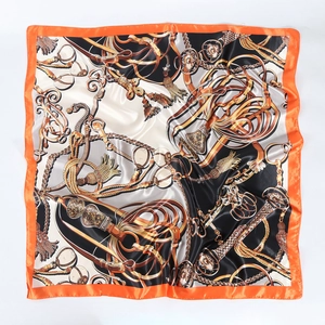 Detailed macro shot of vintage horse harness print on satin square scarf with orange border