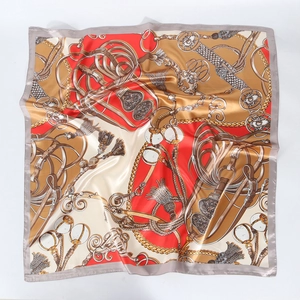 Macro view of printed square silk scarf showing equestrian patterns and satin finish