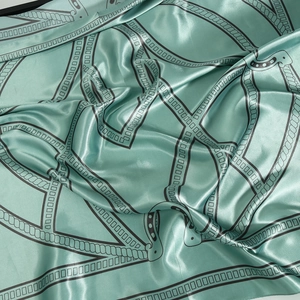 Detail of mint green silk scarf with geometric rope patterns and satin glossy finish