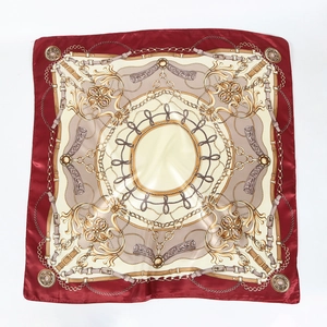 Détail d'un foulard en satin bordeaux et beige avec motifs de chaînes dorées rétro