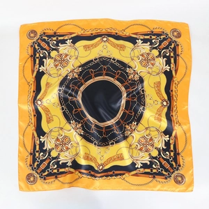 Détail d'un foulard carré en satin avec imprimé de chaînes vintage et boucles orange et noir
