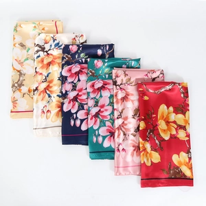 Detail showing various colors of 90cm floral silk scarves with magnolia print texture