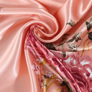 Pink satin square scarf featuring vibrant red rose floral prints and silky smooth texture