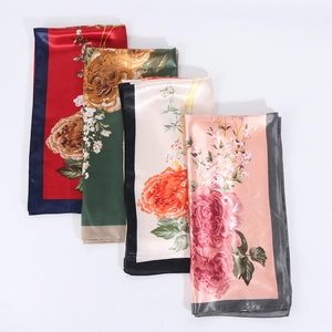 Detail of four floral satin scarves in red, green, beige and pink with smooth silk texture