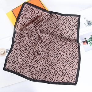 Detail of leopard print silk scarf with black border on elegant lifestyle background