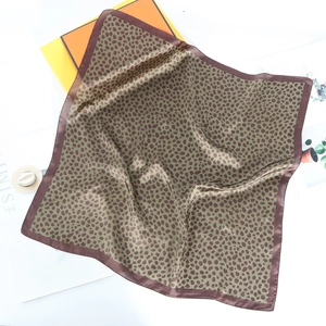 Detail of leopard print silk scarf with satin edges and premium orange gift box