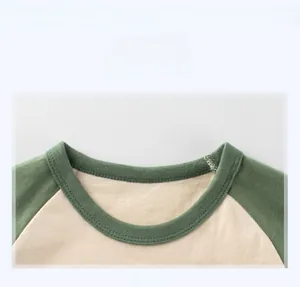 Détail de l'encolure côtelée verte sur un t-shirt raglan pour enfant avec couture fine