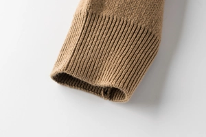 Macro view of ribbed knit cuffs on camel brown kids sweater with soft wool texture