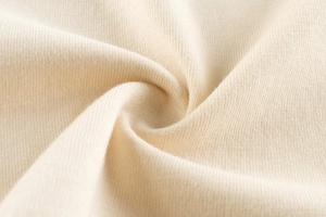 Macro du tissu en maille de coton crème montrant la texture douce pour t-shirt enfant