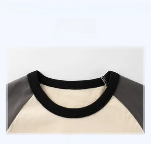 Détail de l'encolure contrastée sur ce t-shirt enfant à manches raglan beige et gris