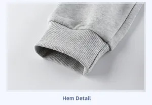 Dettaglio dei polsini elastici a coste su pantaloni sportivi grigio chiaro per bambini