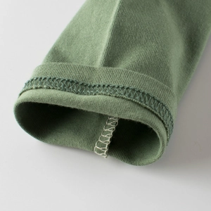 Détails des coutures soignées et qualité du tricot sur ce t-shirt enfant vert