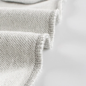 Détail du tissu en coton gris clair et des coutures pour pantalons de sport enfant
