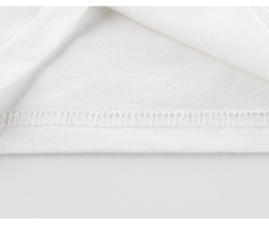Zoom sur le tissu en coton blanc avec ourlet professionnel à double piqûre du t-shirt enfant