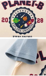 Détail d'un T-shirt enfant à thème spatial avec motifs de fusées et coutures renforcées