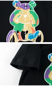 Detail eines bunten Bärenprints und der Doppelnaht am Ärmel eines schwarzen Baumwoll-T-Shirts
