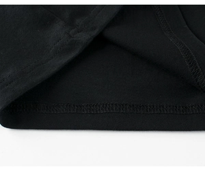 Nahaufnahme der präzisen Doppelnaht am Saum eines schwarzen Kinder-T-Shirts aus Baumwolle