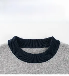 Detail of color-block crew neck sweater with navy ribbed collar and gray knit fabric